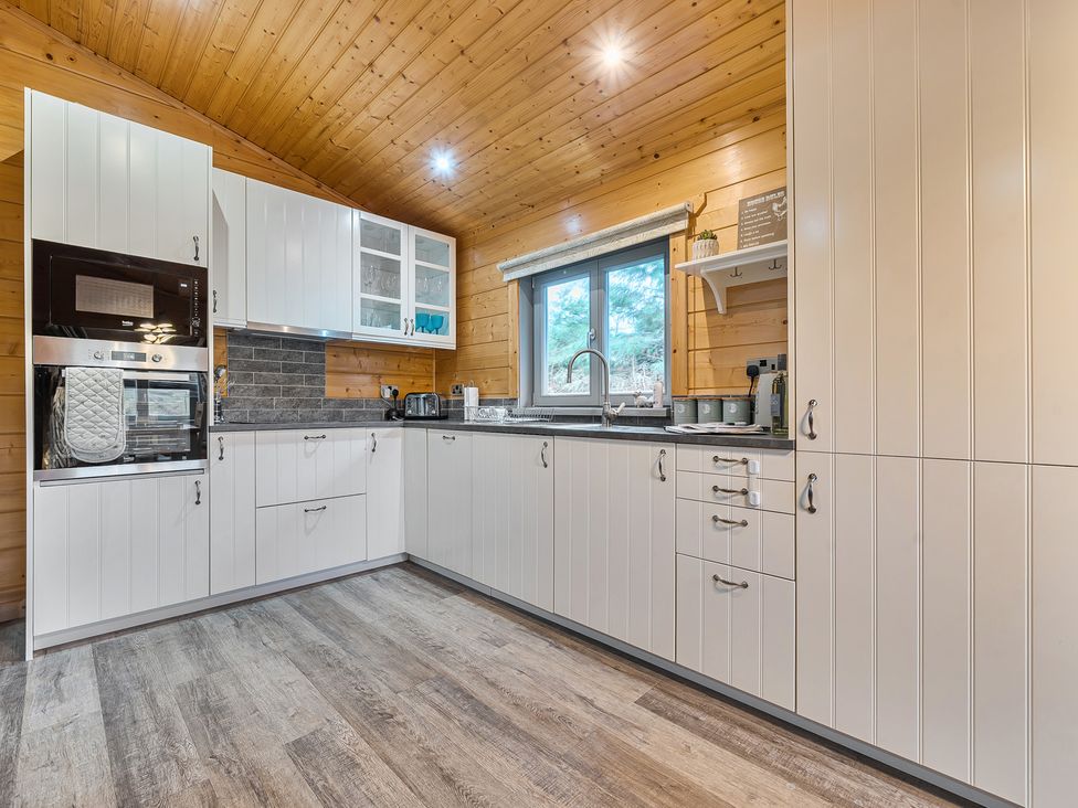 A kitchen with cabinets and appliances at Elm Lodge in Ulverston