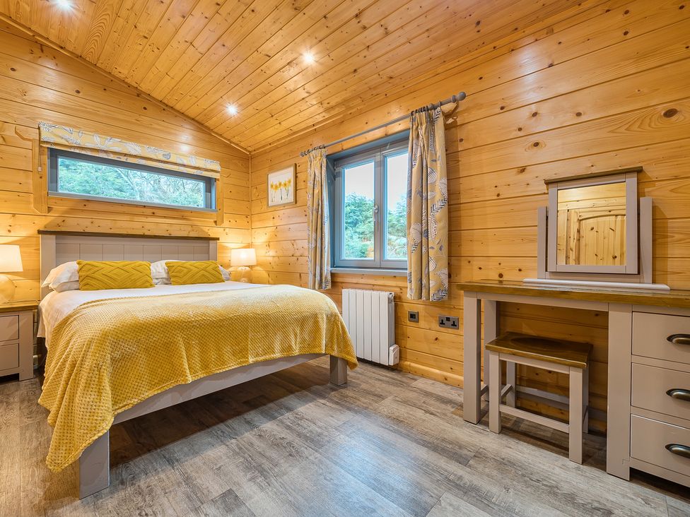 A bedroom with a bed and dressing table at Elm Lodge in Ulverston