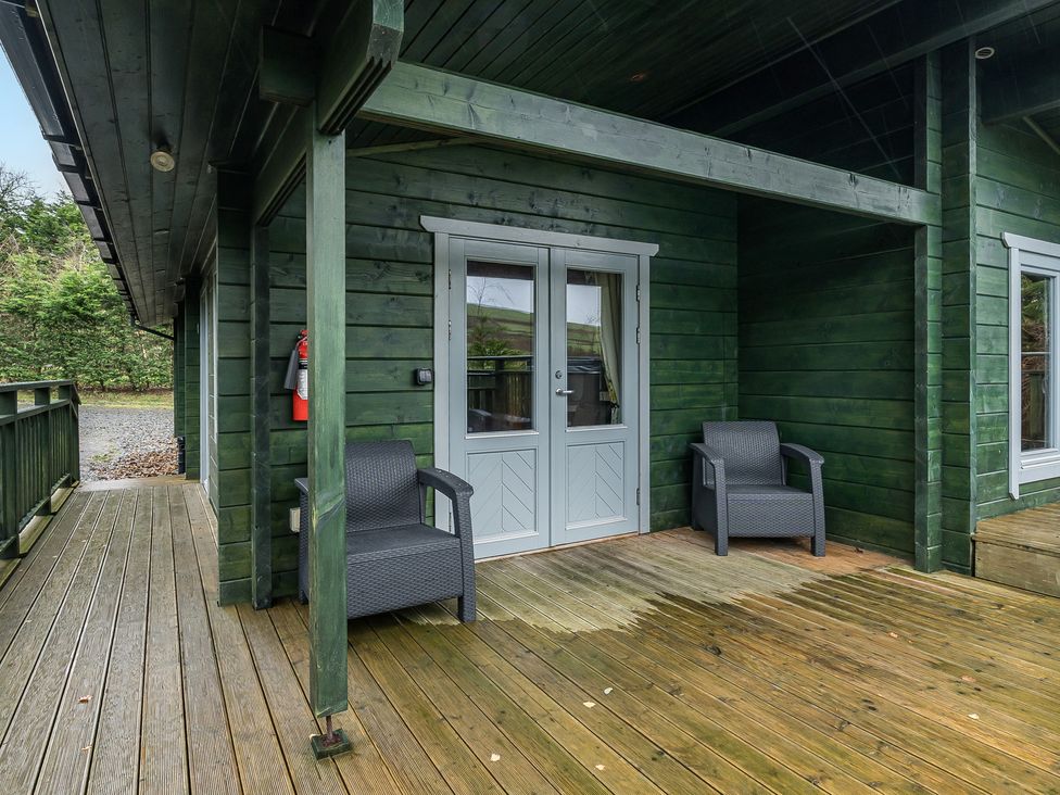 An outdoor area with chairs and a front door at Elm Lodge in Ulverston