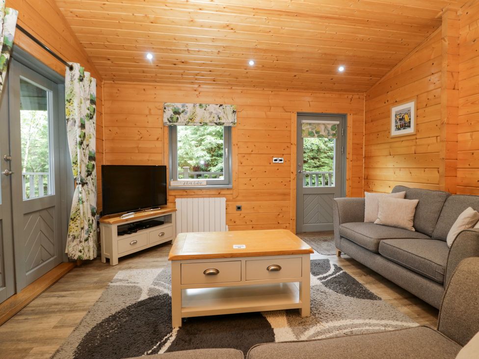 A living room with a sofa, coffee table, and television at Elm Lodge in Ulverston