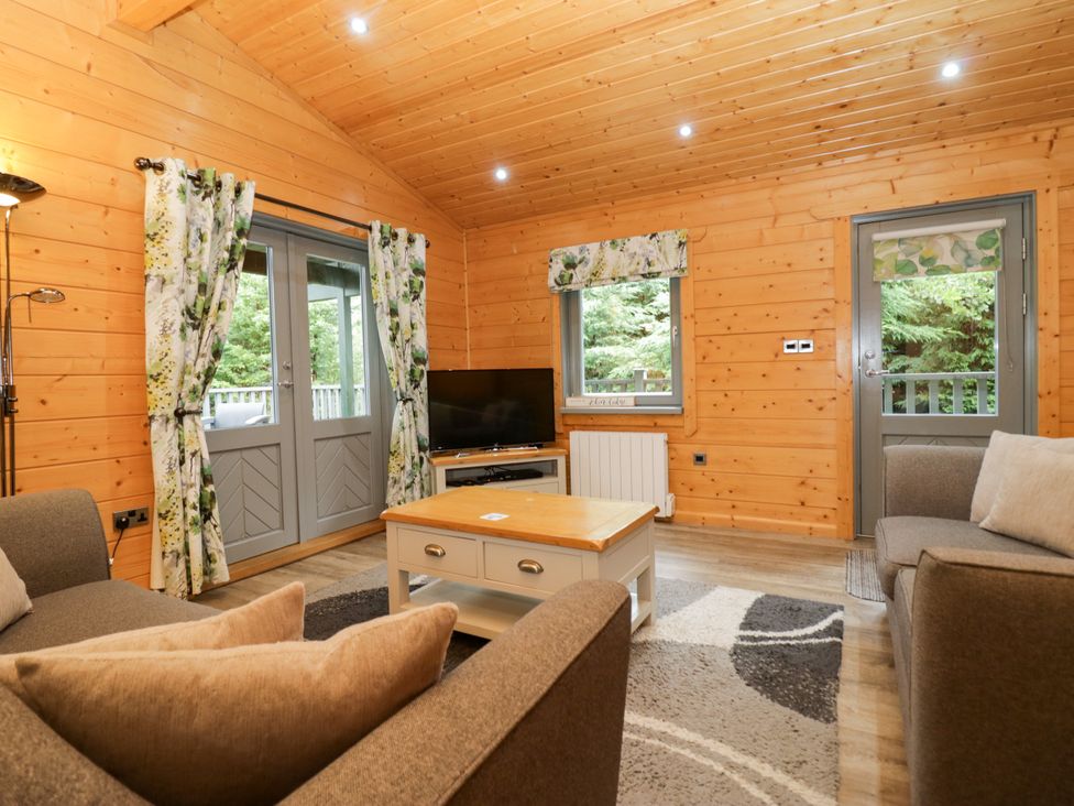 A living room with a sofa and television at Elm Lodge in Ulverston