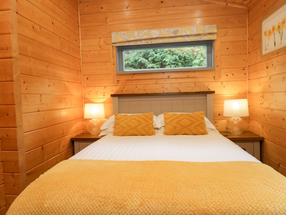 A bedroom with a bed and lamps at Elm Lodge in Ulverston
