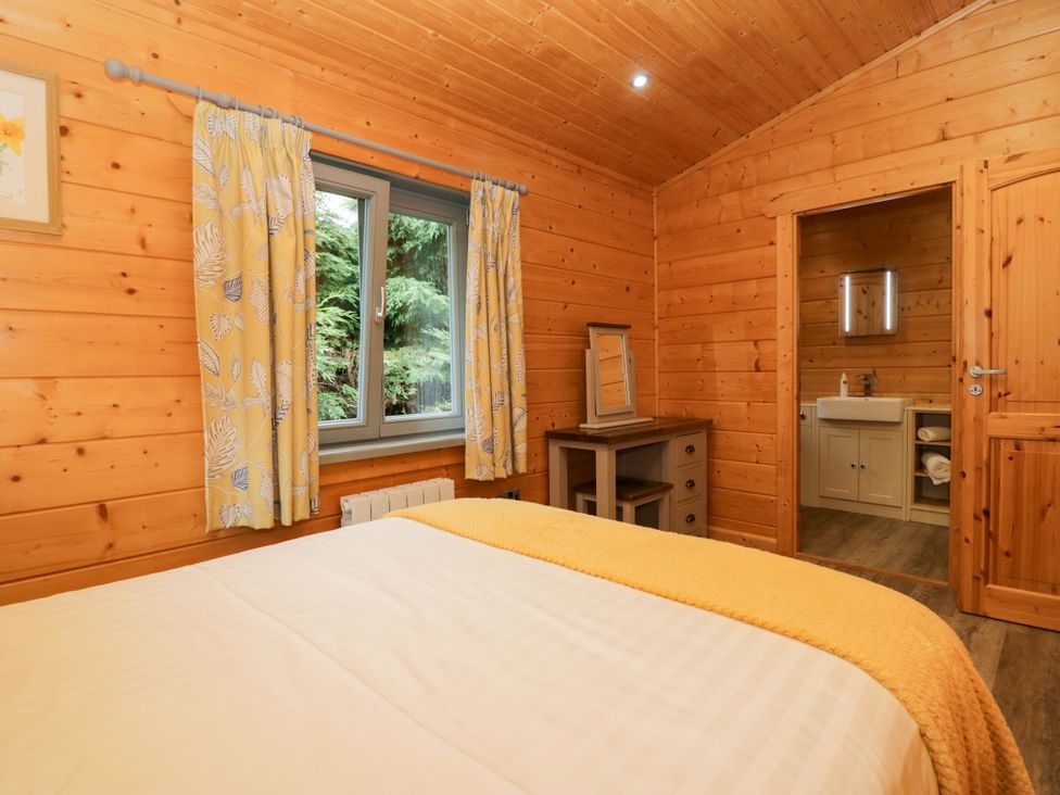 A bedroom with a bed and a bathroom at Elm Lodge in Ulverston