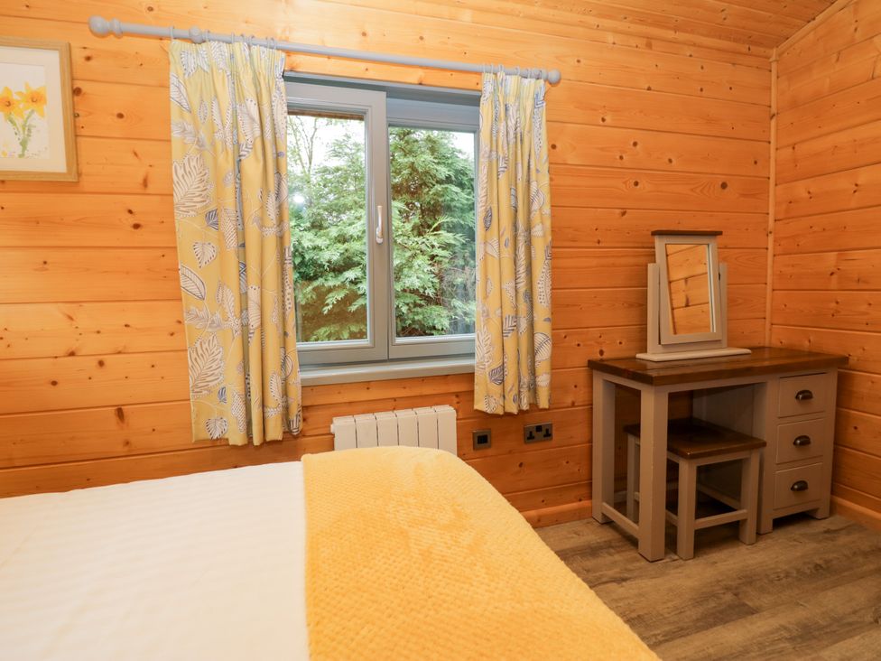 A bedroom with a bed and desk at Elm Lodge in Ulverston