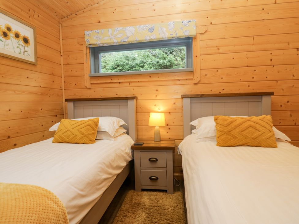 A bedroom with two single beds and a window at Elm Lodge in Ulverston