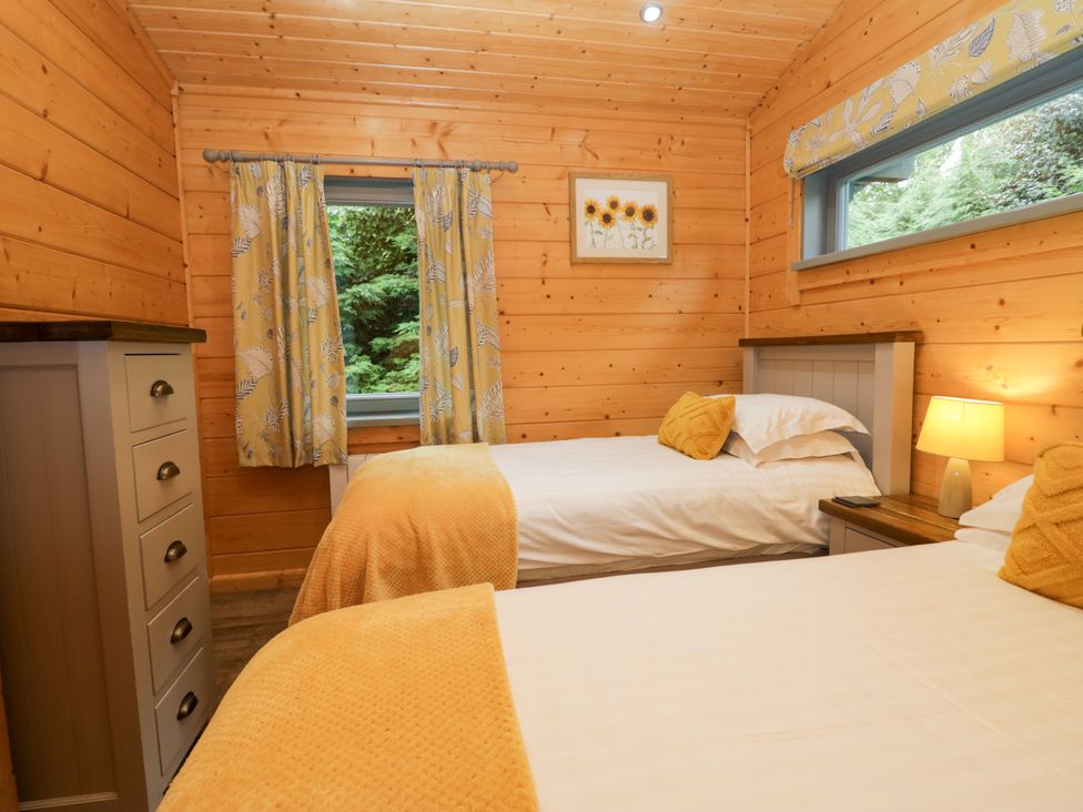 A bedroom with two beds and a window at Elm Lodge in Ulverston