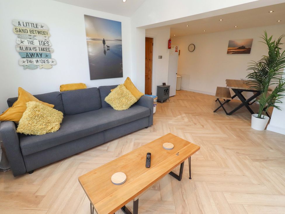 A living room with a sofa and table at Sunrise Cottage Beadnell
