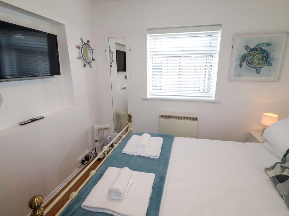 A bedroom with a bed and television at Sunrise Cottage Beadnell
