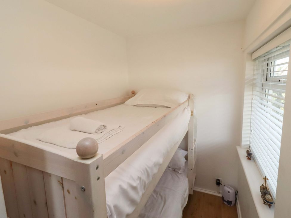 A bunk bed with bedding in a bedroom at Sunrise Cottage Beadnell