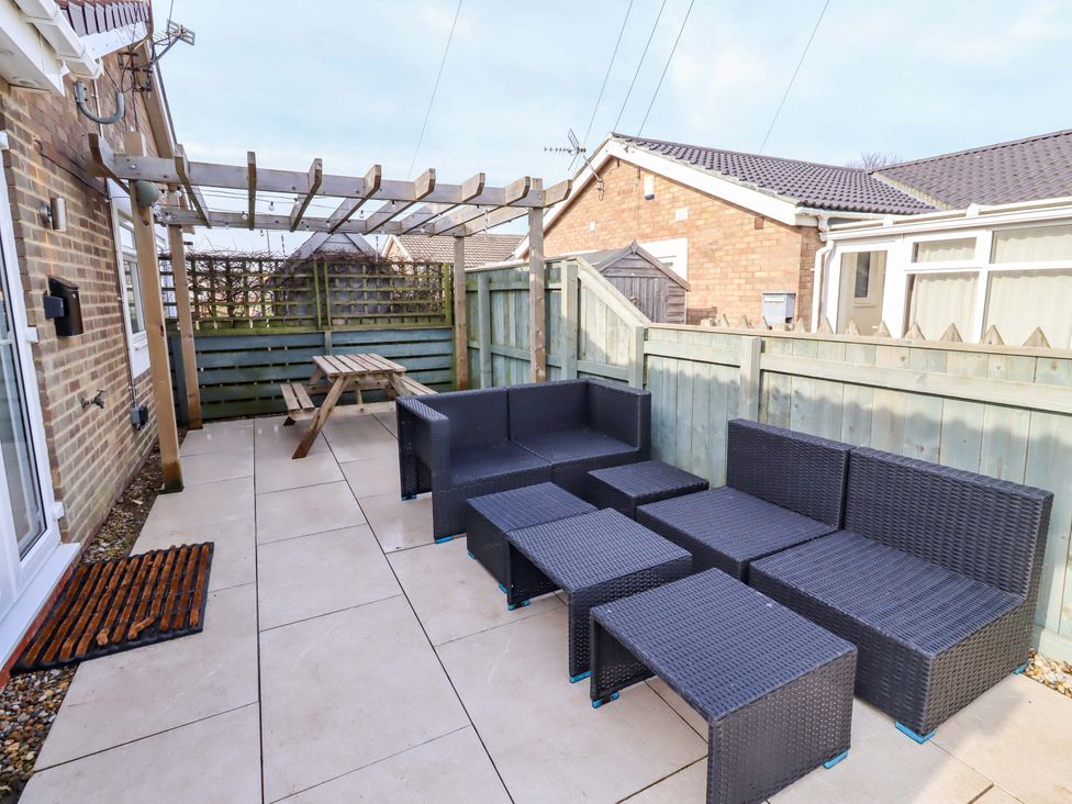 An outdoor patio with seating and a table at Sunrise Cottage Beadnell