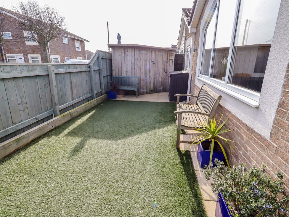A garden with a bench and plants at Sunrise Cottage Beadnell