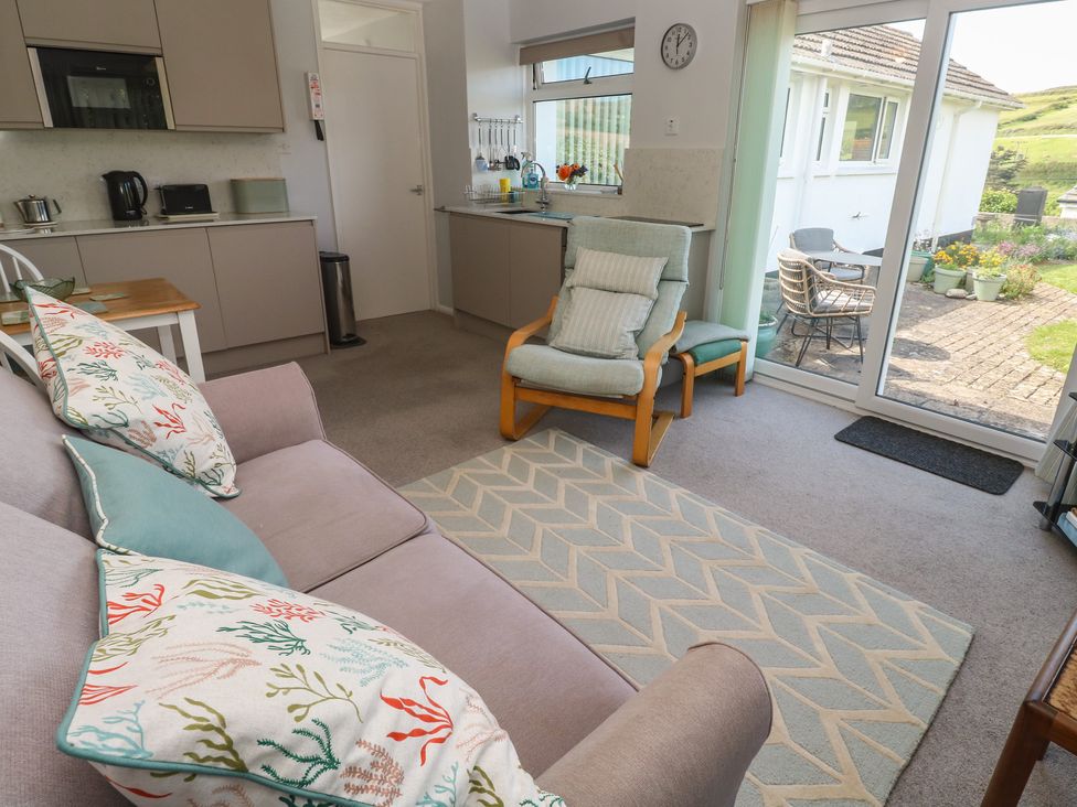 A living room with a sofa and kitchen area at Bre An Mor in Praa Sands