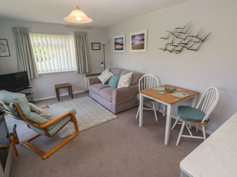 A living room with a sofa and dining area at Bre An Mor in Praa Sands