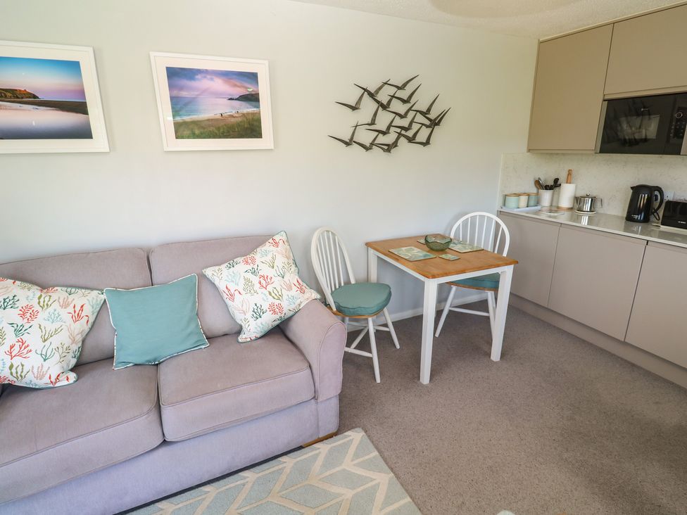 A living area with a sofa and dining table at Bre An Mor in Praa Sands
