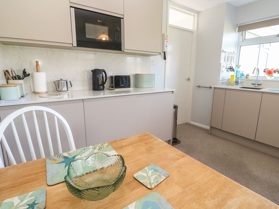 A kitchen with appliances and dining table at Bre An Mor Praa Sands