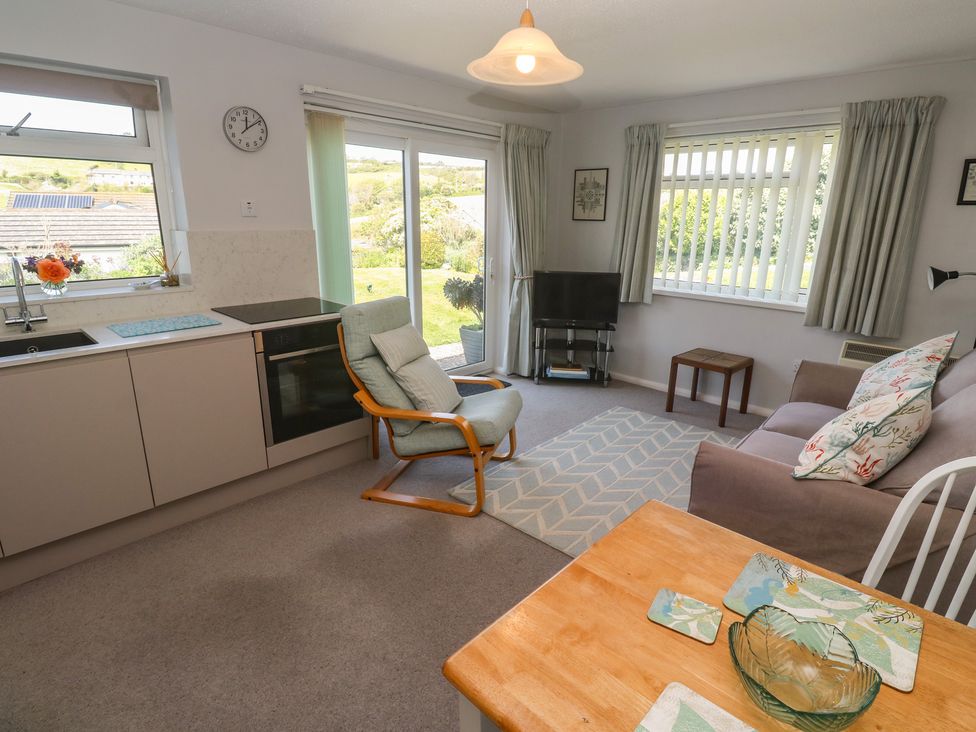 A living room with a kitchen and seating area at Bre An Mor in Praa Sands