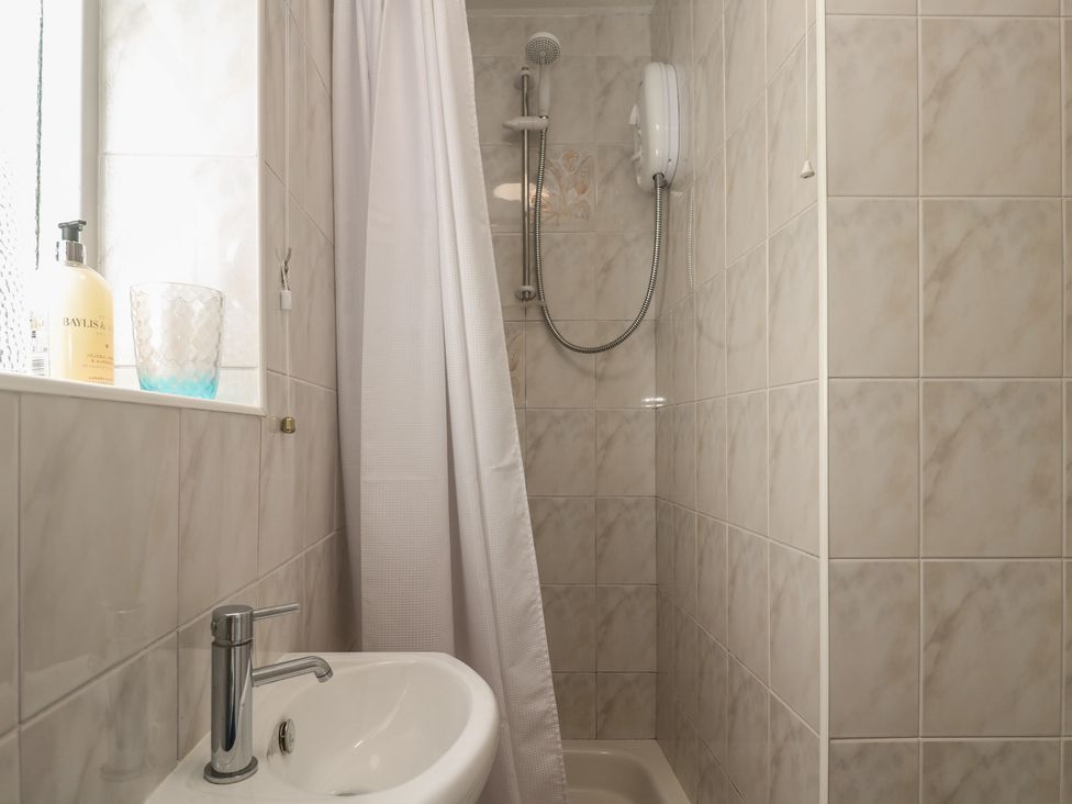A shower area with a shower head and soap dispenser at Bre An Mor in Praa Sands