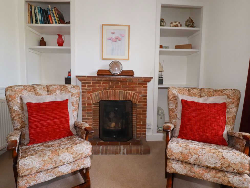 A sitting room with two armchairs and a fireplace at Penrose Farm Cottage St Keverne