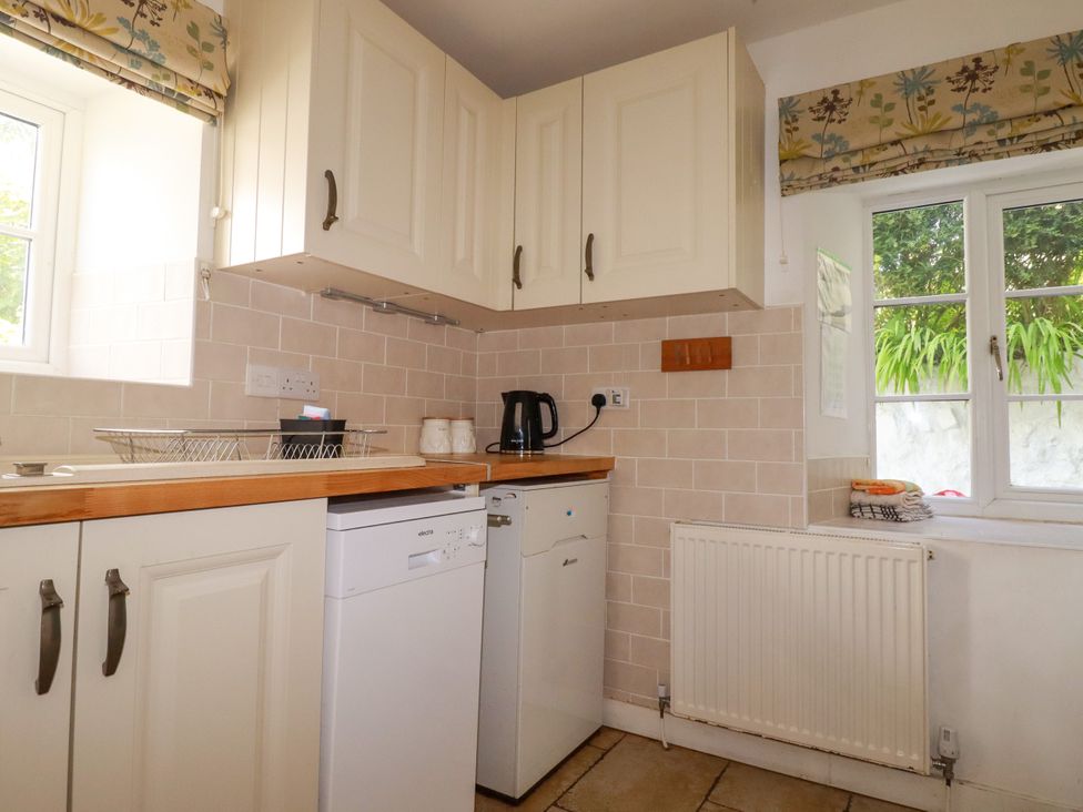 A kitchen with cabinets and appliances at Penrose Farm Cottage St Keverne