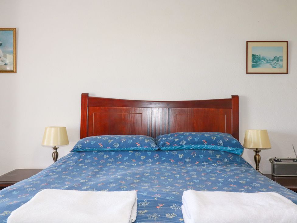 A bedroom with a bed and bedside lamps at Penrose Farm Cottage St Keverne