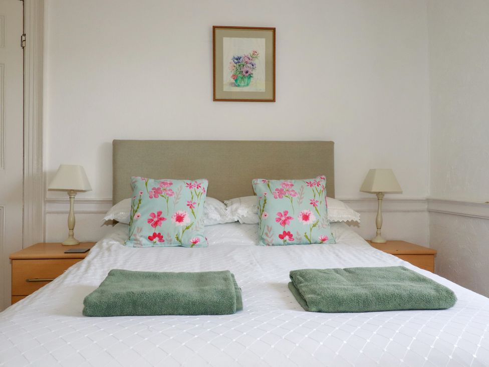 A bedroom with a bed, pillows, and a lamp at Penrose Farm Cottage St Keverne