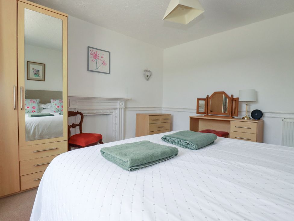 A bedroom with a bed and dresser at Penrose Farm Cottage St Keverne
