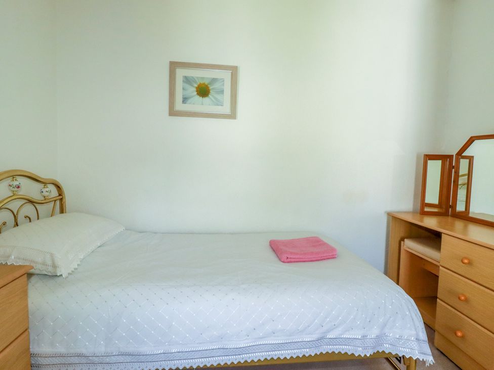 A bedroom with a bed and mirror at Penrose Farm Cottage St Keverne
