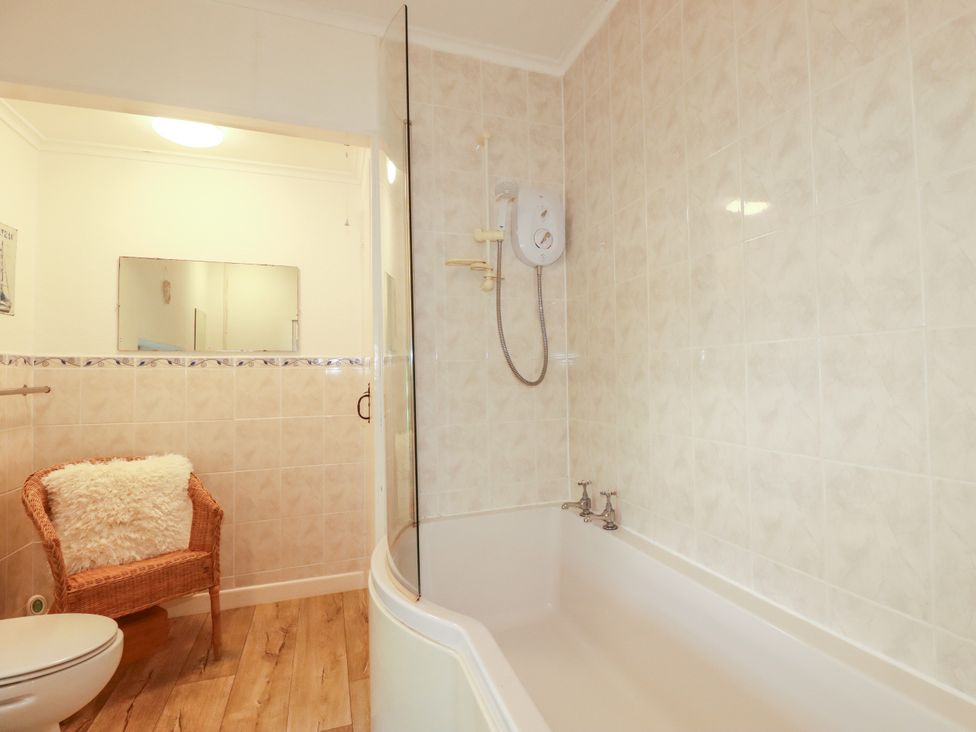 A bathroom with a bathtub and shower at Penrose Farm Cottage St Keverne