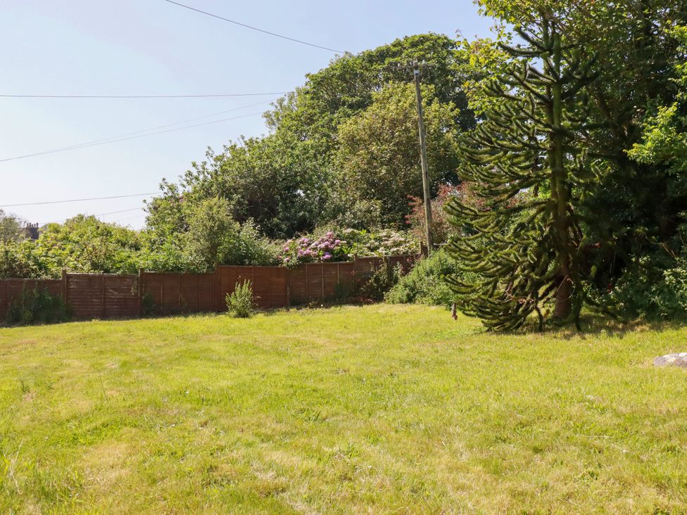 A garden with grass and trees at Penrose Farm Cottage St Keverne