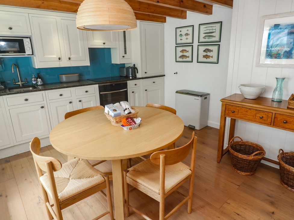 A kitchen with a round table and chairs at Pegs in Porthleven