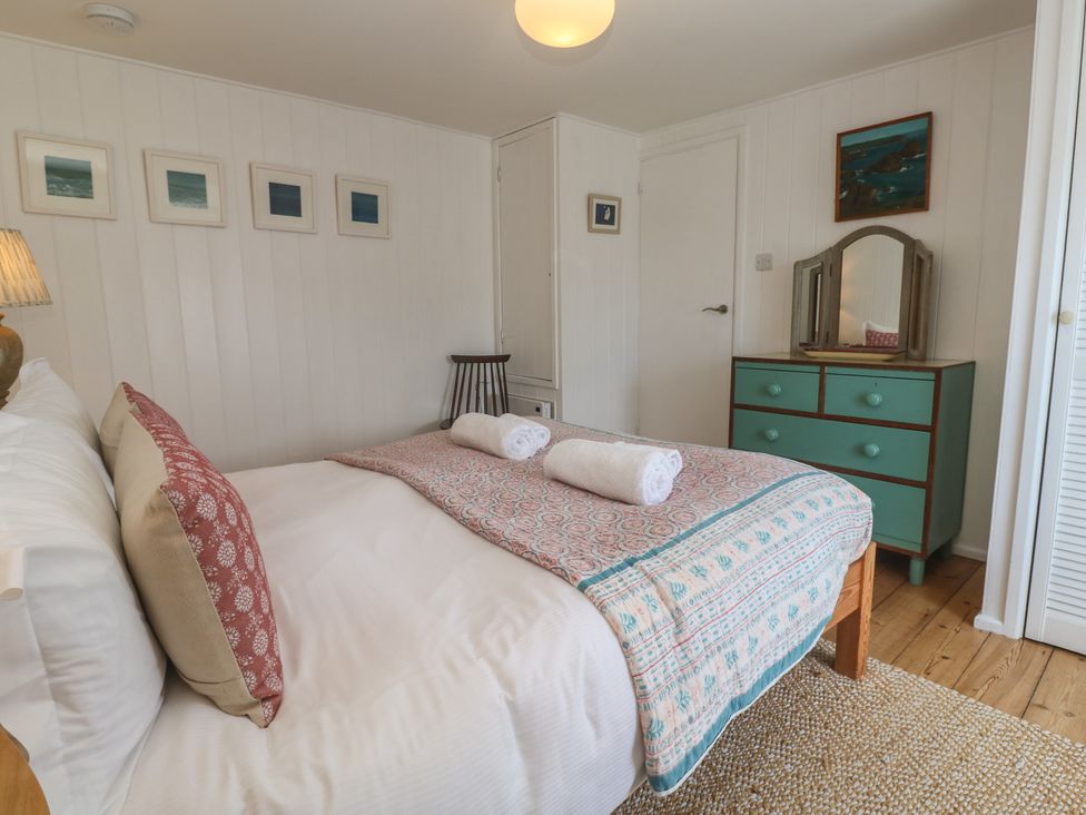 A bedroom with a bed and dresser at Pegs in Porthleven