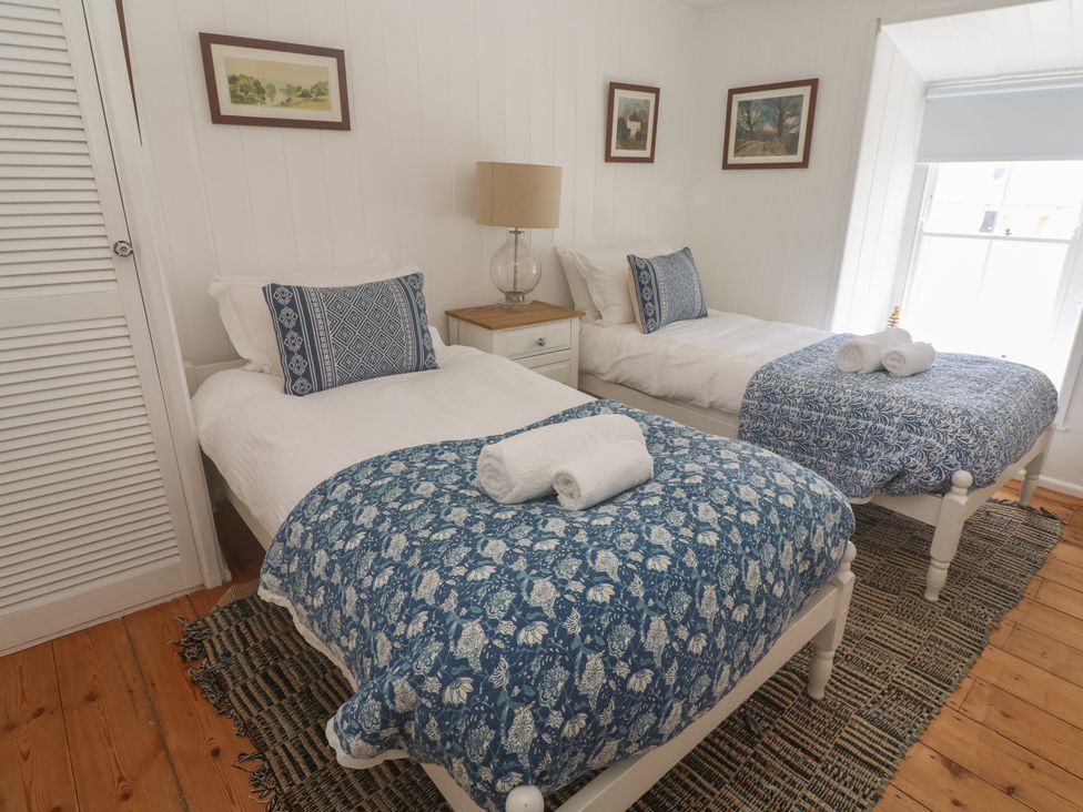 A bedroom with two beds and a nightstand at Pegs in Porthleven