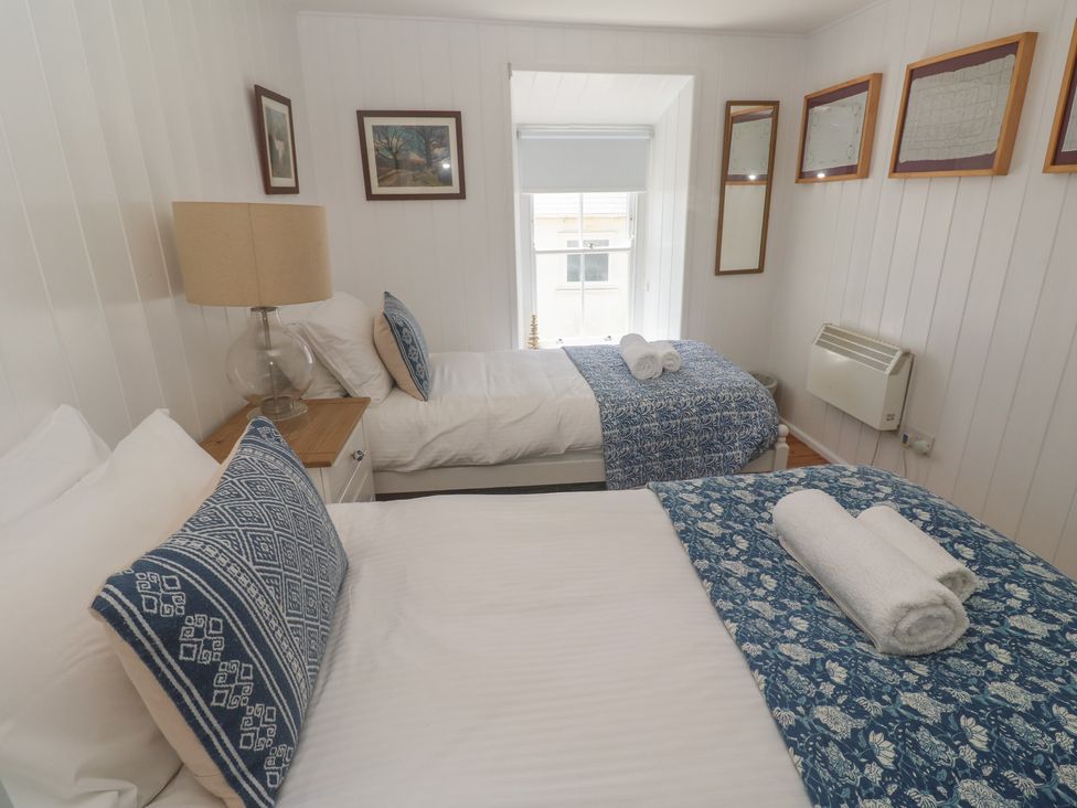 A bedroom with two beds and a lamp at Pegs in Porthleven
