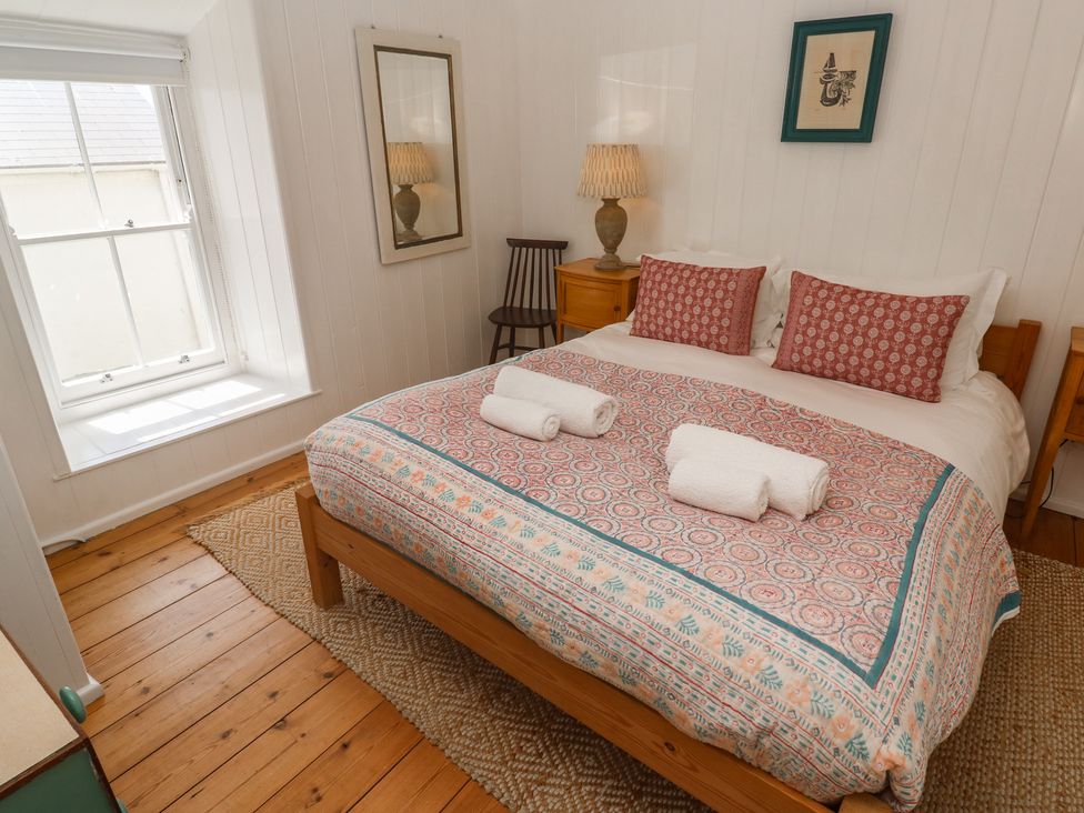 A bedroom with a bed and nightstand at Pegs in Porthleven