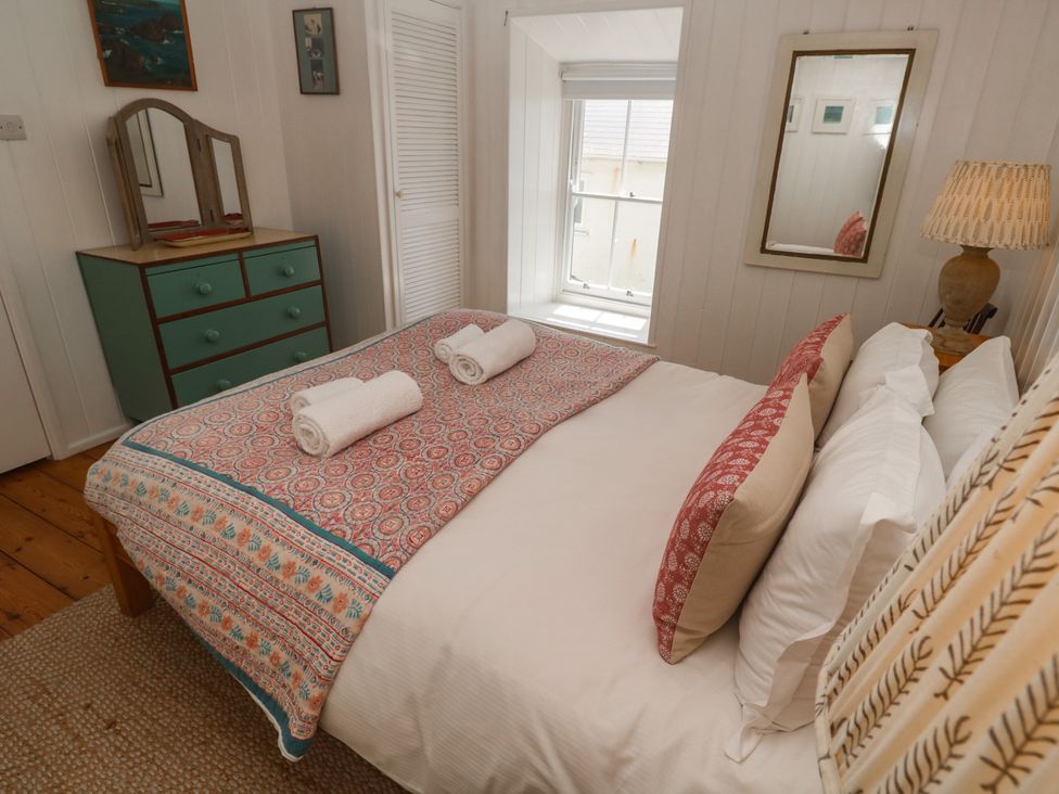 A bedroom with a bed and dresser at Pegs in Porthleven