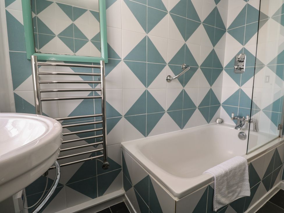 A bathroom with a bathtub and sink at Pegs in Porthleven