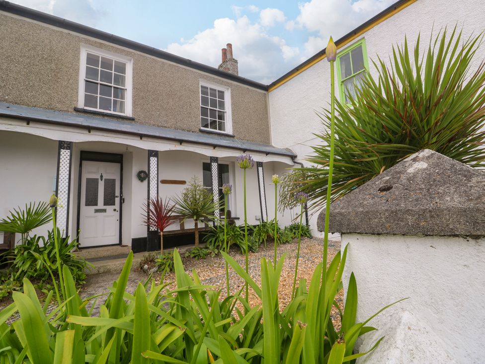 A garden with plants and a door at 1 Dormer Villas in Portscatho