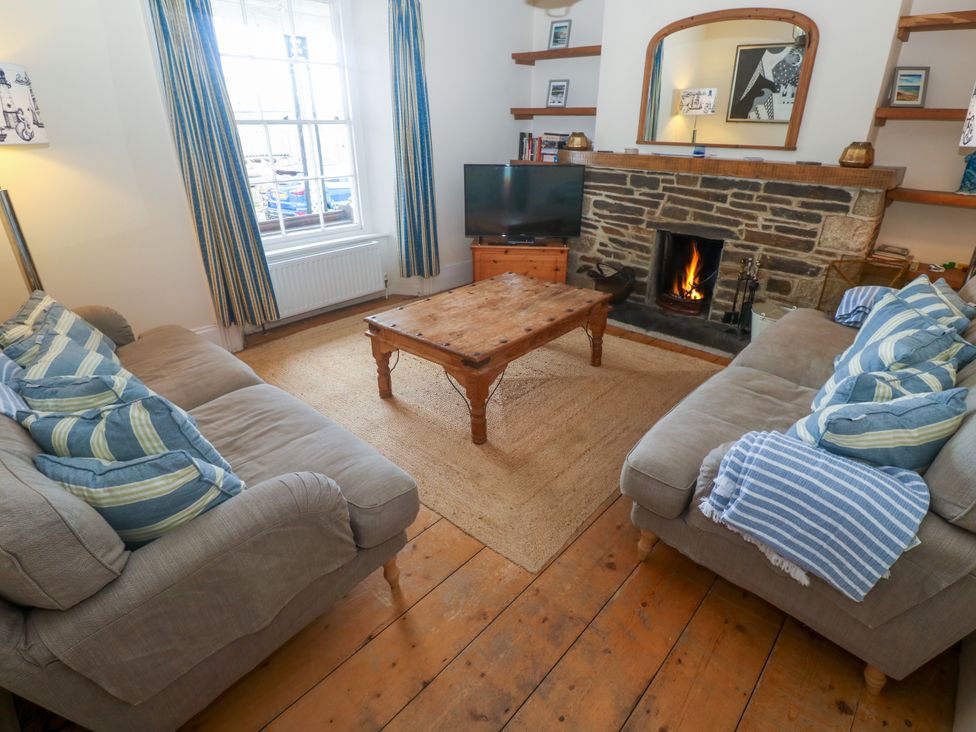 A living room with a coffee table, two sofas, and a fireplace at 1 Dormer Villas in Portscatho