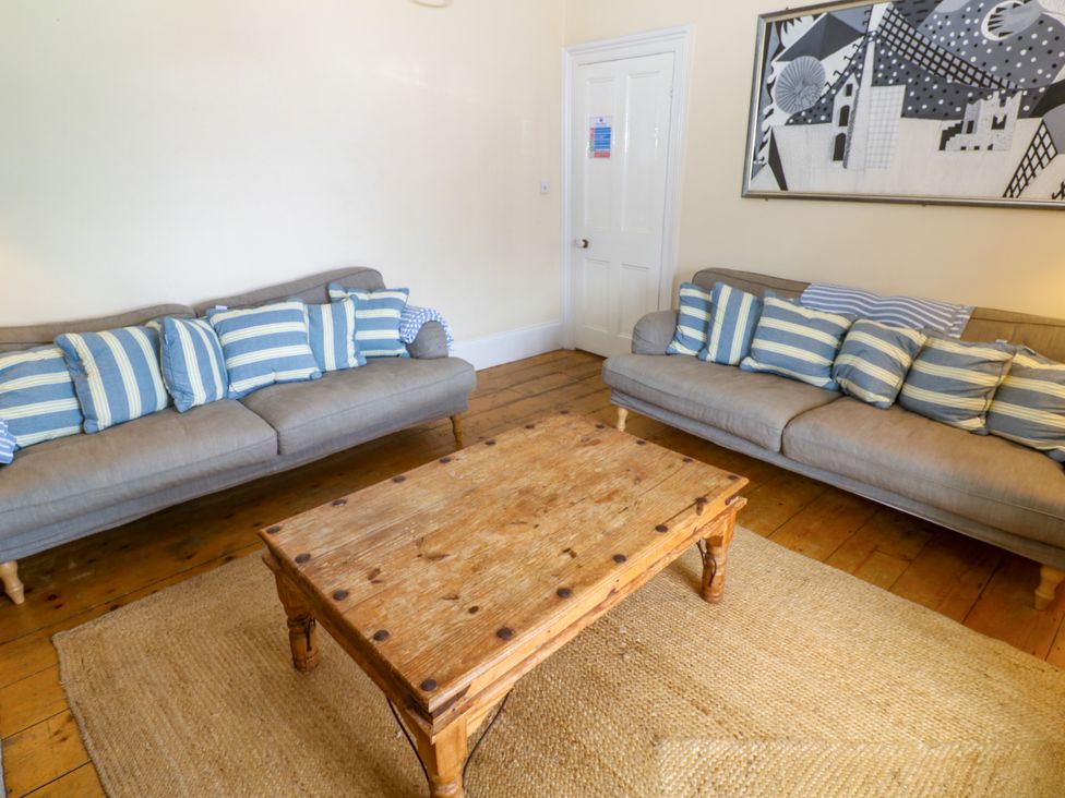 A living room with two sofas and a wooden table at 1 Dormer Villas Portscatho