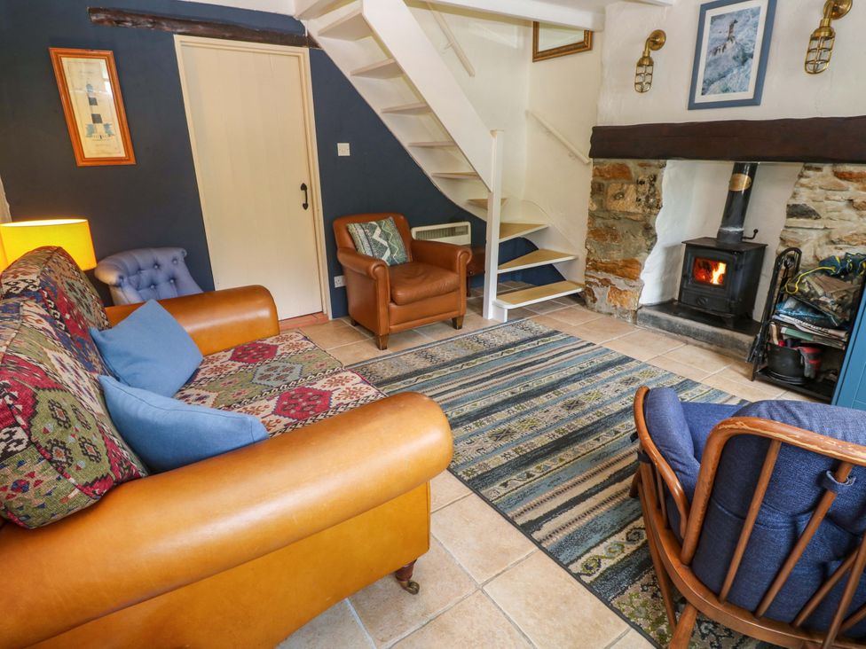 A living room with a sofa and armchair at May Cottage in Pentewan