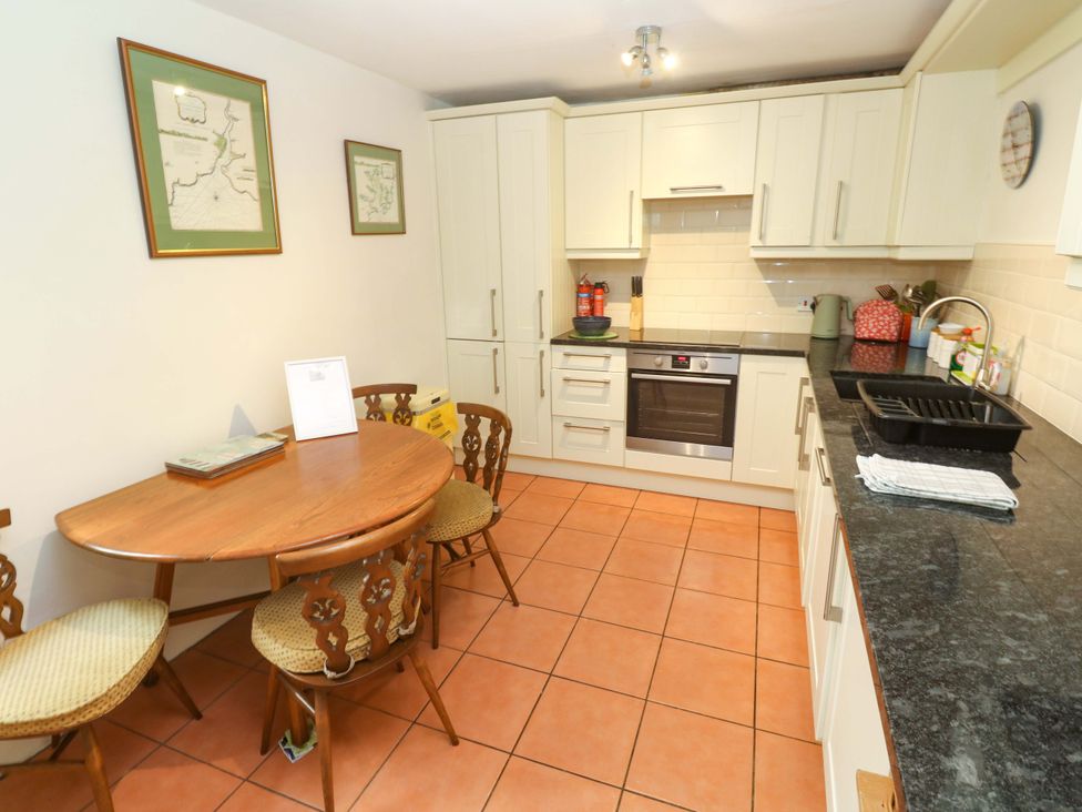 A kitchen with a dining table and chairs at May Cottage in Pentewan