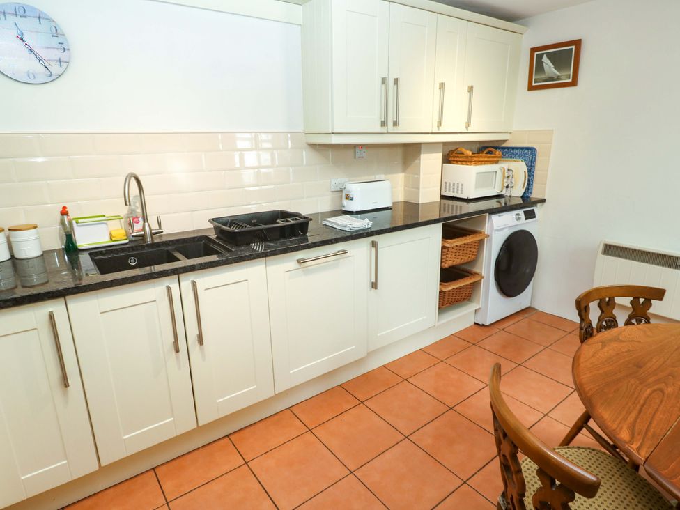 A kitchen with sink and appliances at May Cottage in Pentewan