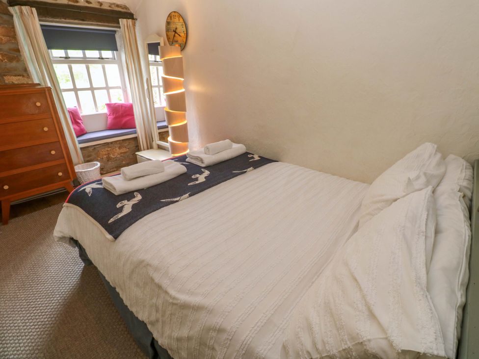 A bedroom with a bed and a chest of drawers at May Cottage Pentewan
