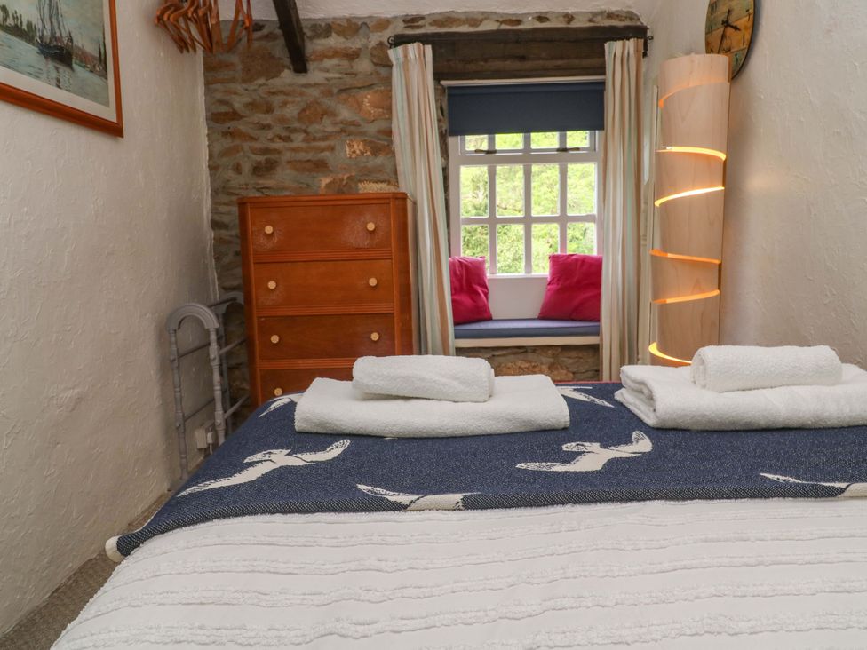 A bedroom with a bed and dresser at May Cottage in Pentewan