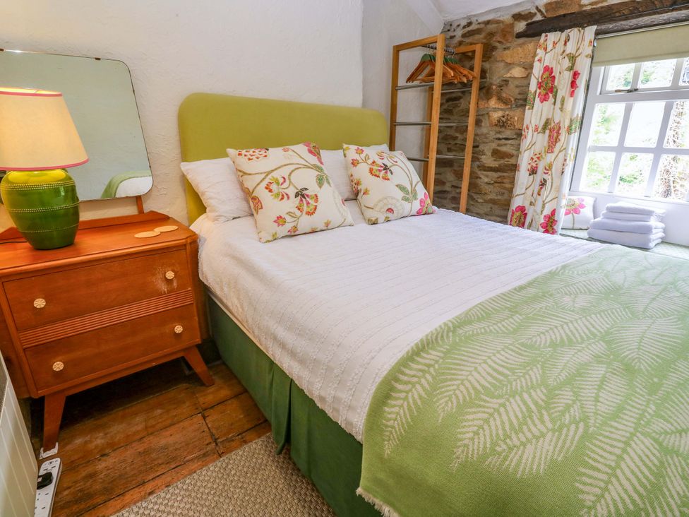 A bedroom with a bed and furniture at May Cottage in Pentewan