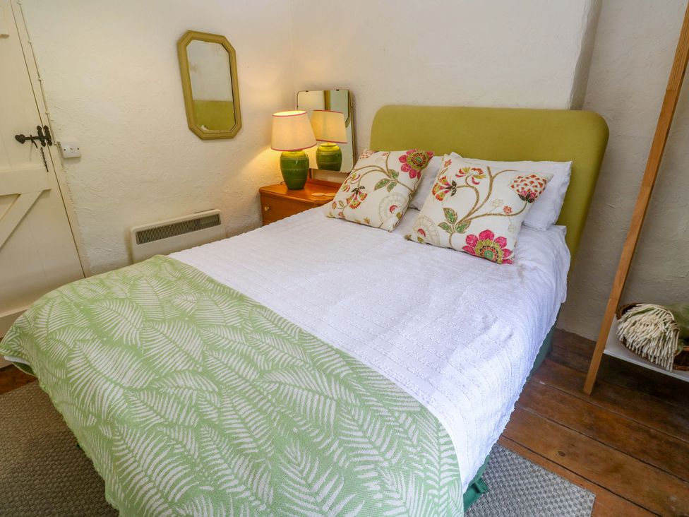 A bedroom with a bed and nightstand at May Cottage in Pentewan