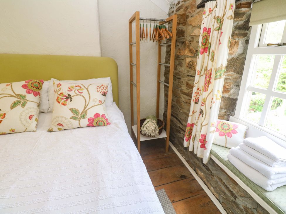A bedroom with a bed and pillows at May Cottage, Pentewan