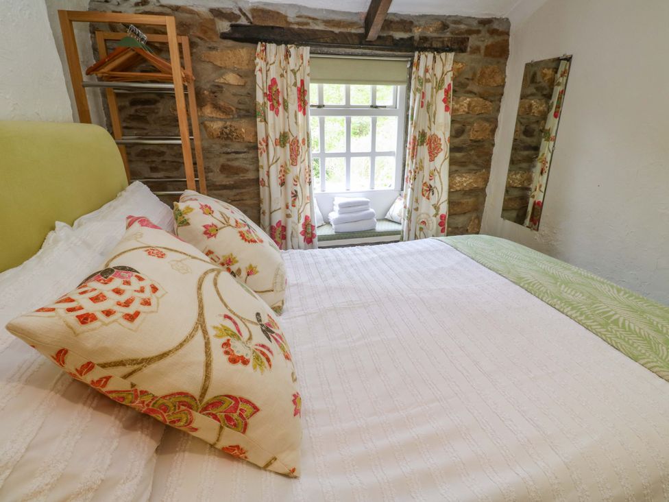 A bedroom with a bed and window at May Cottage in Pentewan