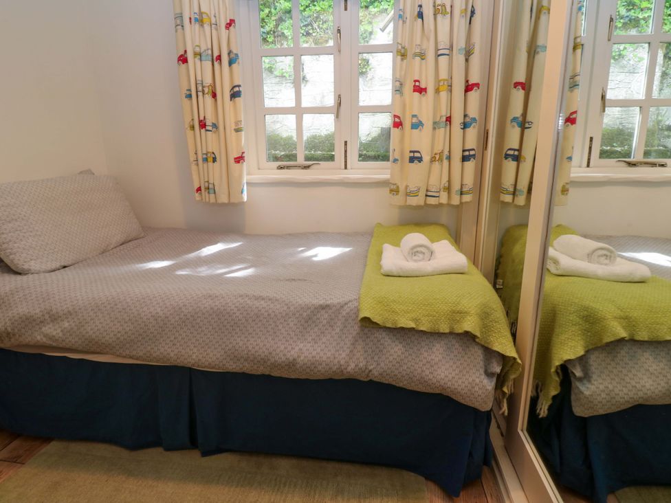 A bedroom with a bed and towels on it at May Cottage in Pentewan