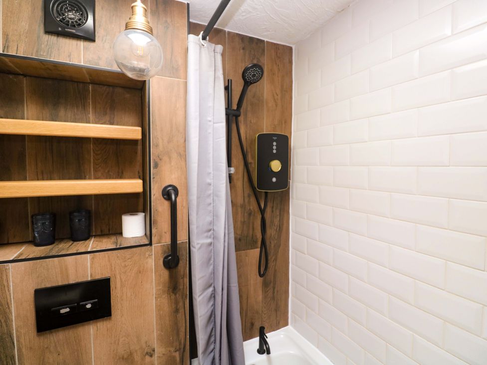 A bathroom with a shower and bathtub at May Cottage in Pentewan